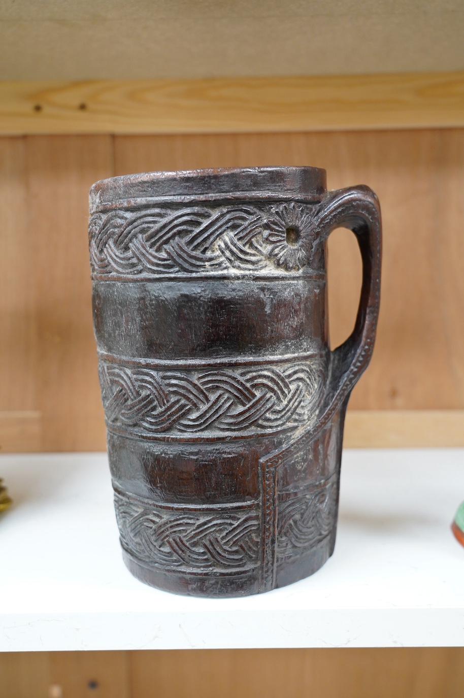 A Scandinavian carved wood tankard, lacking lid, 24cm. Condition - commensurate with age